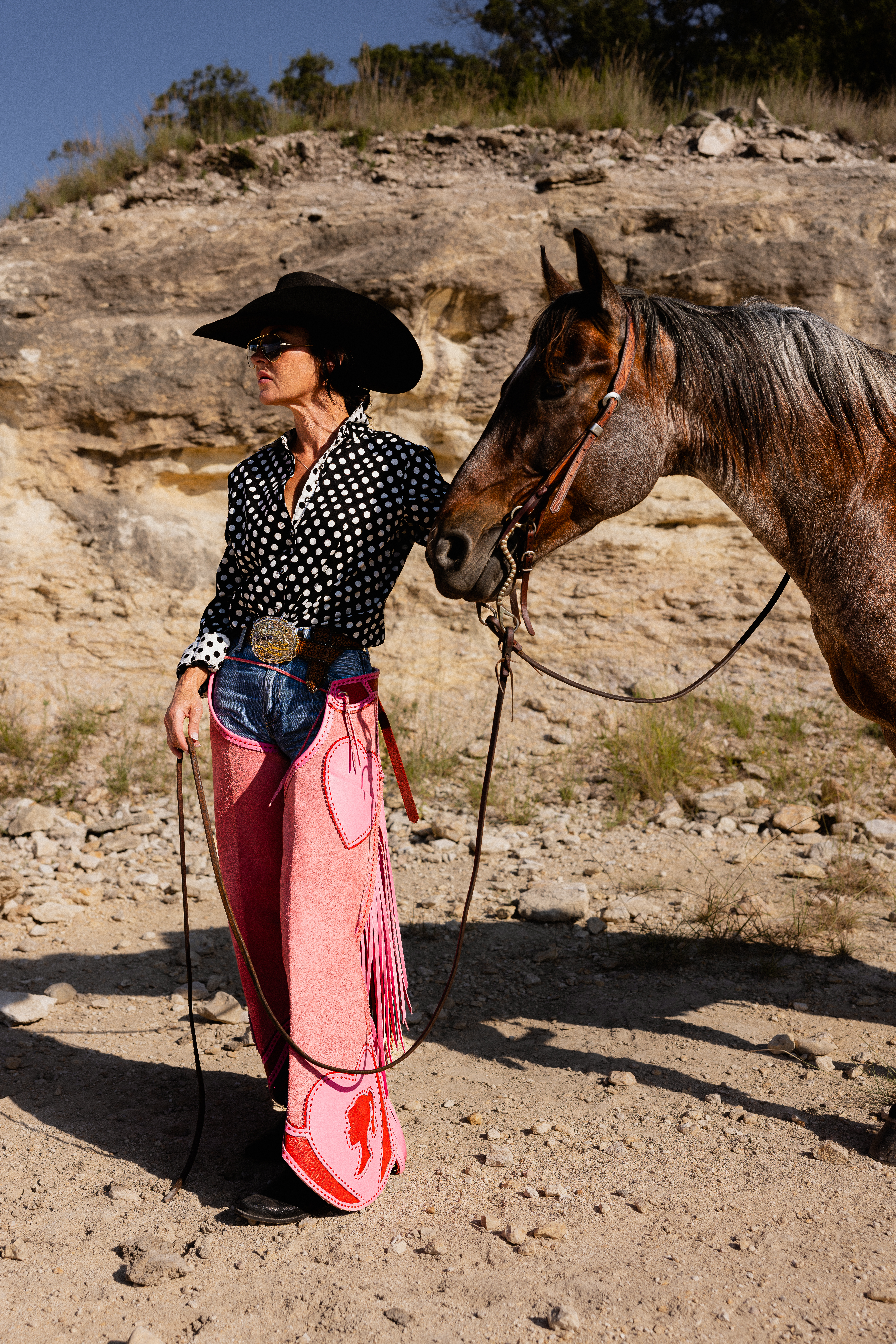Michelle Moore Gesell in pink Western chaps holding her horse